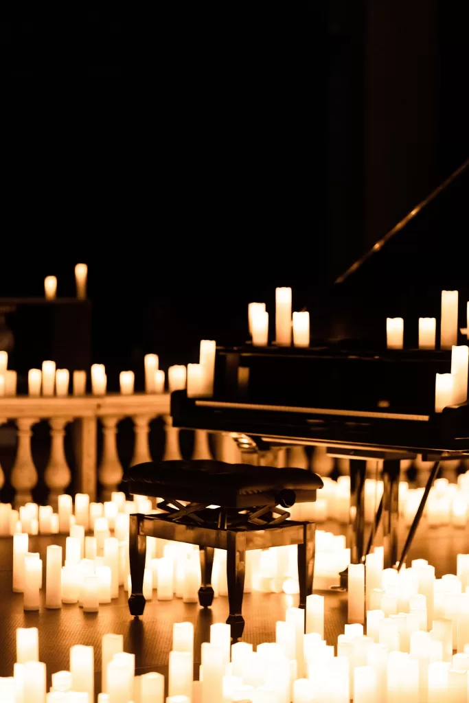 Chair And Piano In A Dark Room Surrounded By Candles