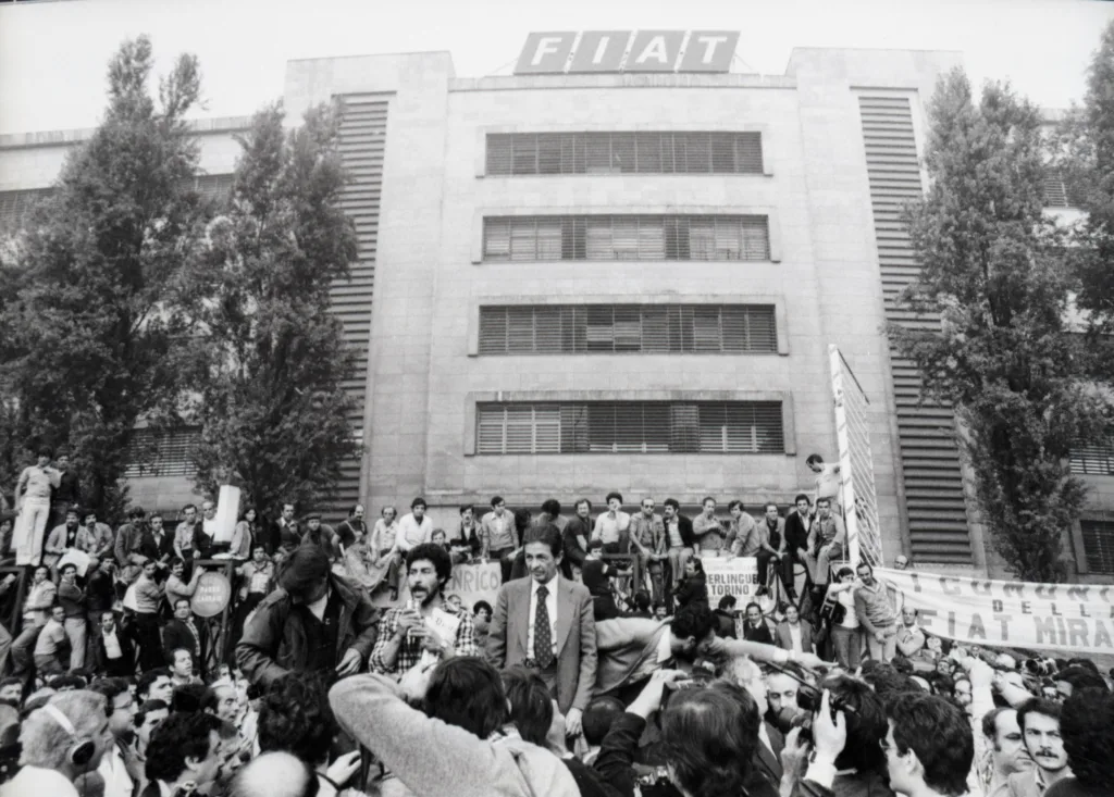 125 Anni di Fiat al MAUTO, Torino: Mostra dal 15 Novembre 2024 al 4 Maggio 2025 1 1980. Marcia dei 40.000 - Comizio di Enrico Berlinguer
davanti alla porta 5 di Mirafiori